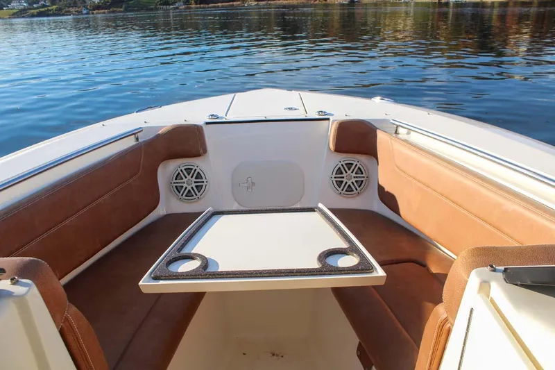 Slide: The Image of 2018 Scout 275 Dorado boat interior with seating and table on calm water. - 16