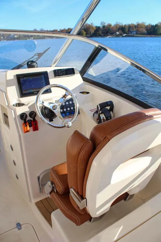 Slide: The Image of 2018 Scout 275 Dorado boat helm with brown leather seat and modern controls. - 22