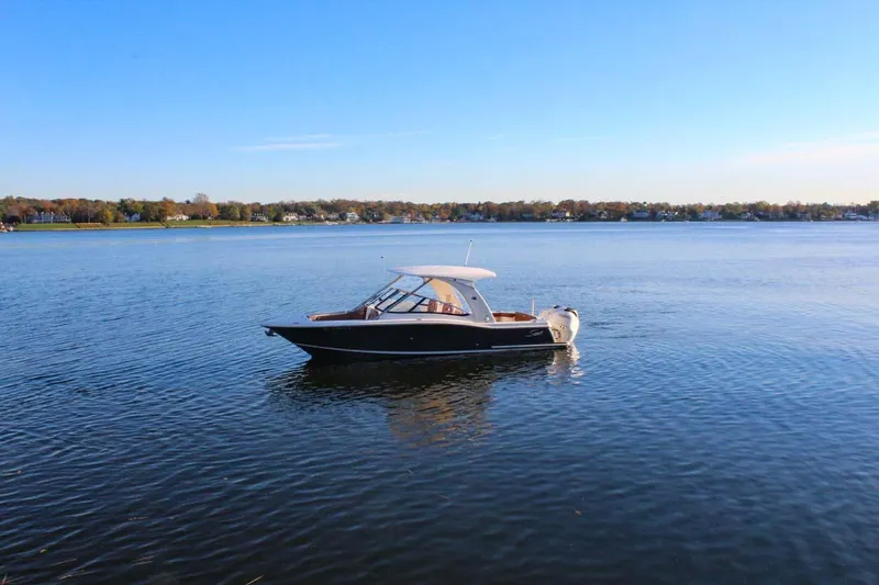 Slide: The Image of 2018 Scout 275 Dorado boat on calm lake with clear blue sky. - 25