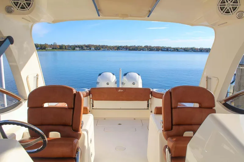 Slide: The Image of 2018 Scout 275 Dorado boat interior with brown seats and scenic water view. - 3