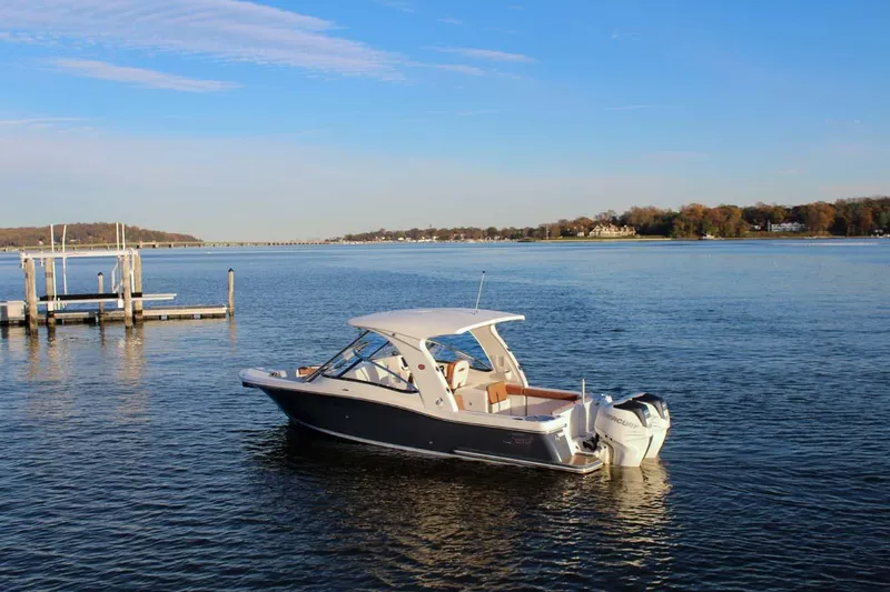 Slide: The Image of 2018 Scout 275 Dorado boat on calm water near a dock. - 32