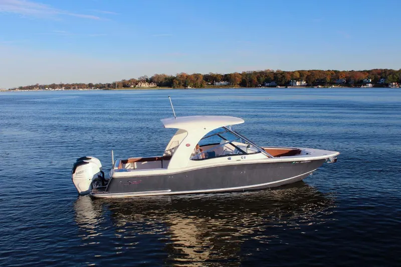 Slide: The Image of 2018 Scout 275 Dorado boat on calm water with scenic shoreline background. - 33