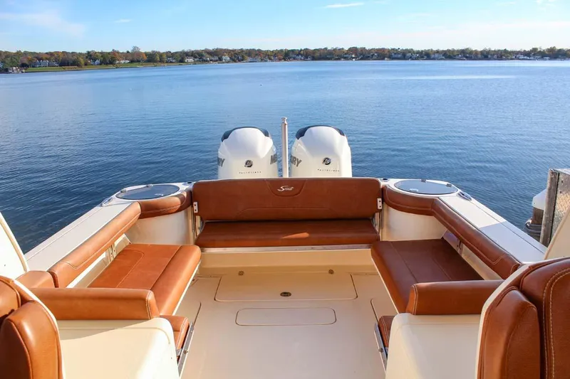 Slide: The Image of 2018 Scout 275 Dorado boat with twin engines and spacious seating on a calm lake. - 6