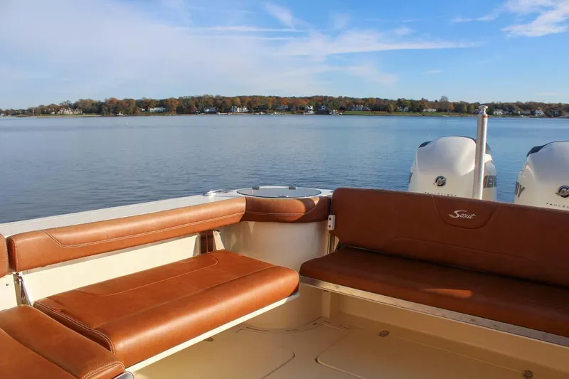 Slide: The Image of 2018 Scout 275 Dorado boat with brown leather seats on a calm lake. - 7
