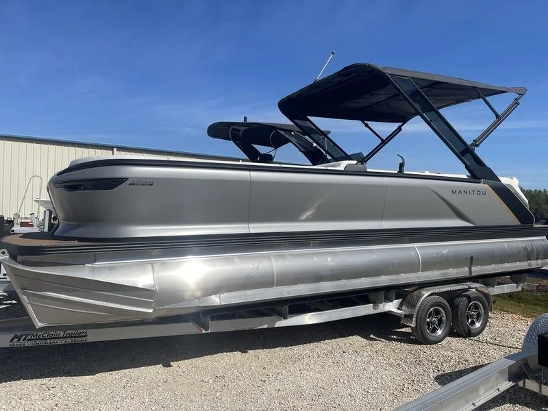 The Image of 2024 Manitou Explore 26 SHP pontoon boat on a trailer, side view. - 1