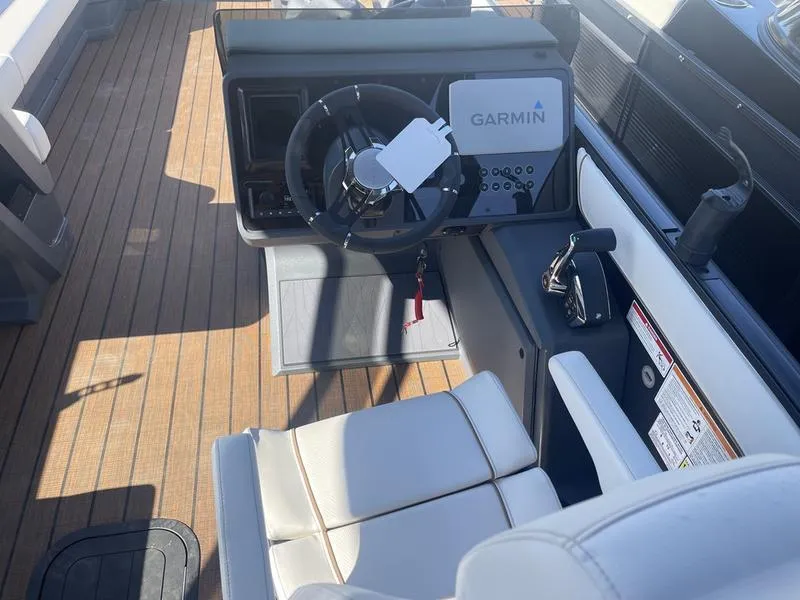 Slide: The Image of 2024 Manitou Explore 26 SHP boat cockpit with Garmin navigation system. - 12