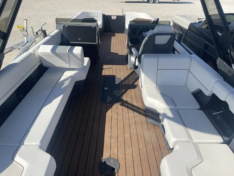 Slide: The Image of 2024 Manitou Explore 26 SHP boat interior with spacious seating and wooden flooring. - 3