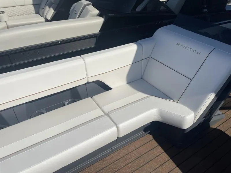 Slide: The Image of 2024 Manitou Explore 26 SHP boat with white cushioned seating. - 4