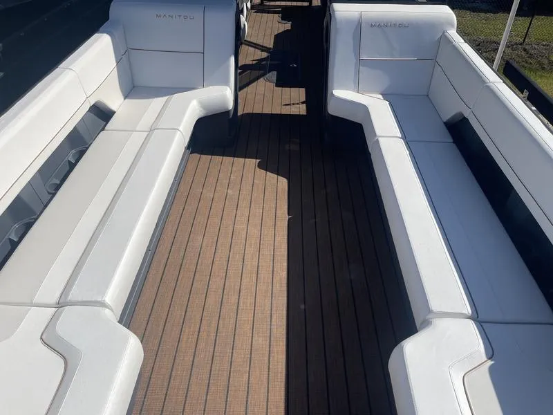 Slide: The Image of 2024 Manitou Explore 26 SHP boat interior with white seating and wooden flooring. - 5