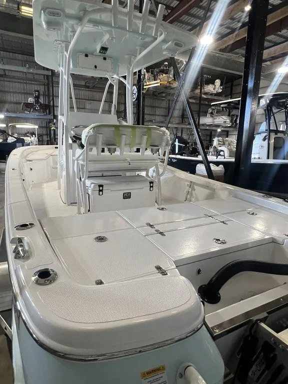 Slide: The Image of 2024 BlackJack 256 Bay boat in showroom, featuring spacious deck and modern design. - 13