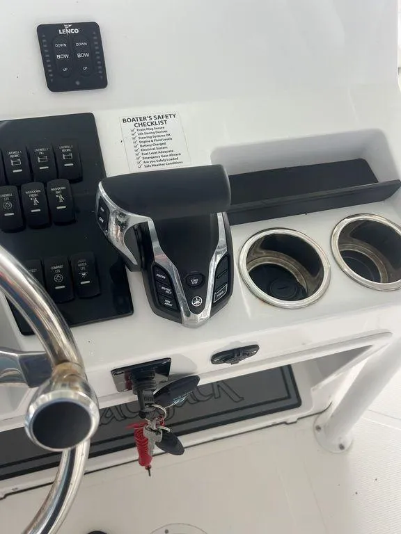 Slide: The Image of 2024 BlackJack 256 Bay boat console with controls and safety checklist. - 25