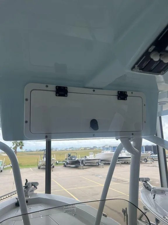 Slide: The Image of 2024 BlackJack 256 Bay boat interior with storage compartment and view of marina. - 27