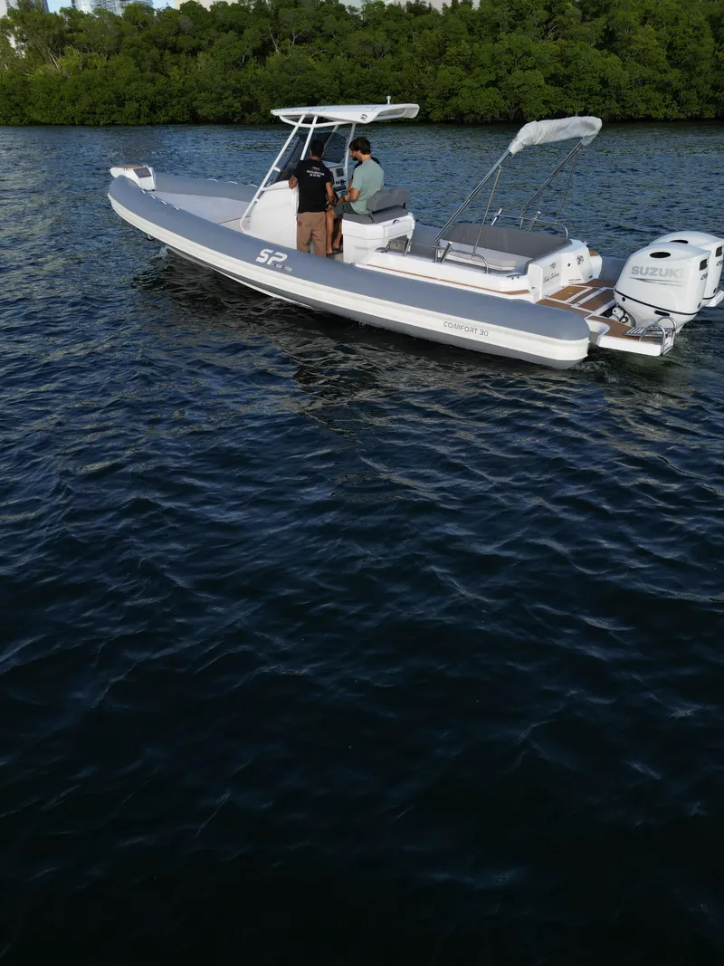 Slide: The Image of 2024 Sea Prop COMFORT 30 boat cruising on a calm lake with two people onboard. - 5
