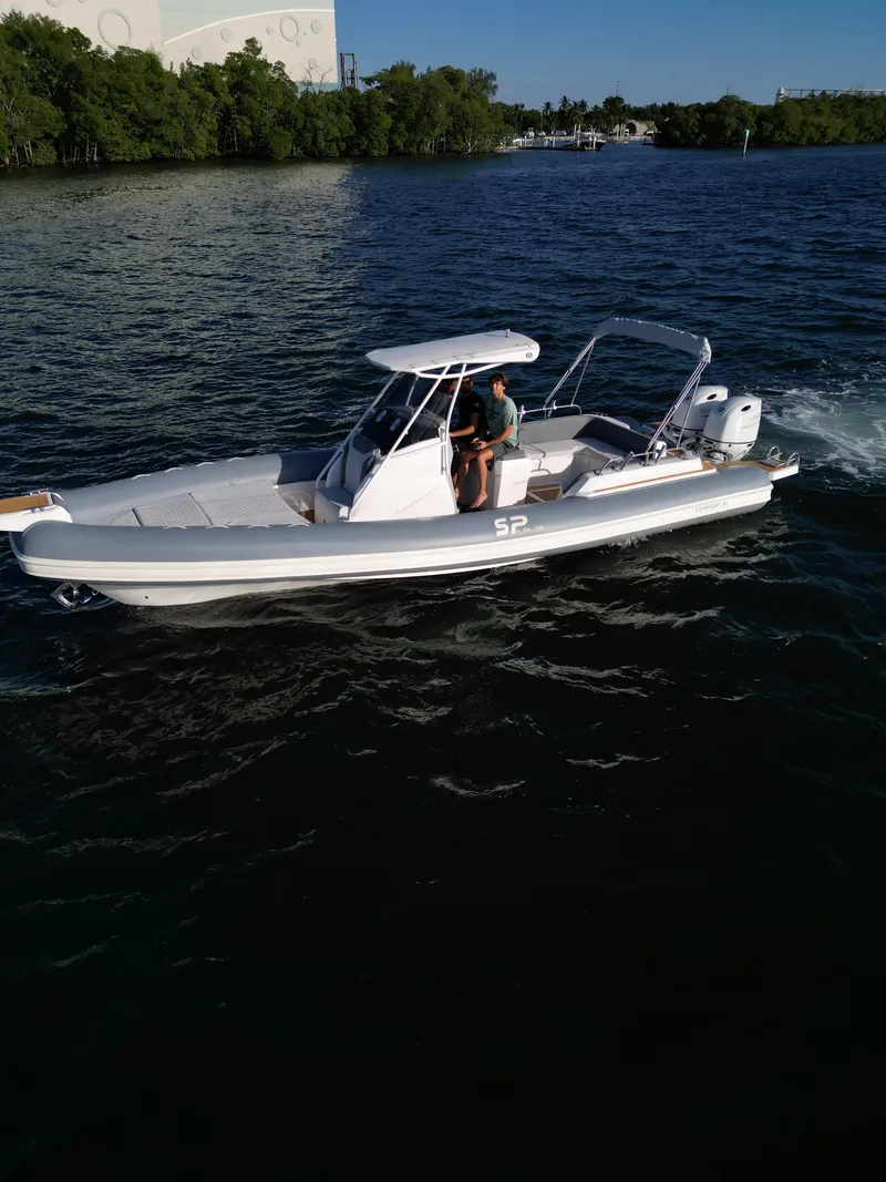 Slide: The Image of 2024 Sea Prop COMFORT 30 boat cruising on a lake with lush green trees in the background. - 6