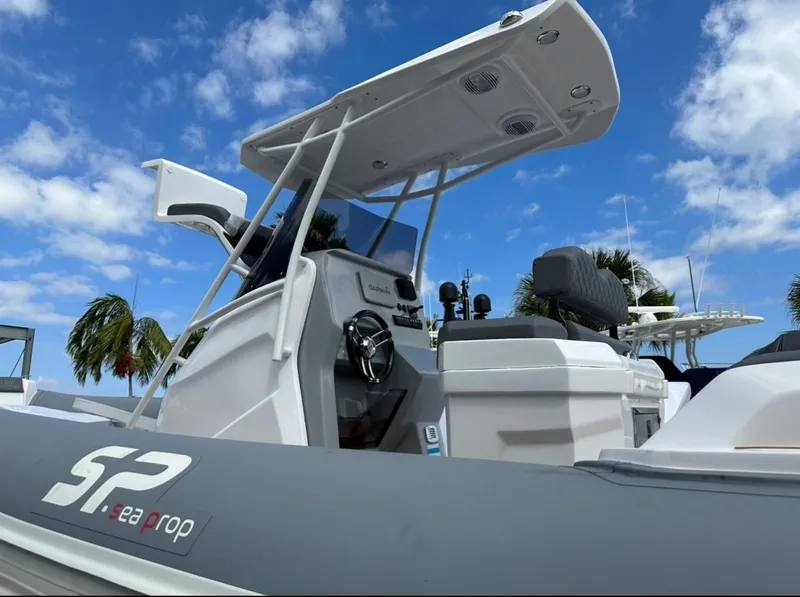 Slide: The Image of 2024 Sea Prop COMFORT 30 boat with modern console and canopy against blue sky. - 9