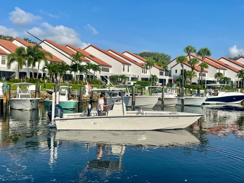 Slide: The Image of Rambo 27 boat (2019) cruising in a marina with waterfront homes in the background. - 0
