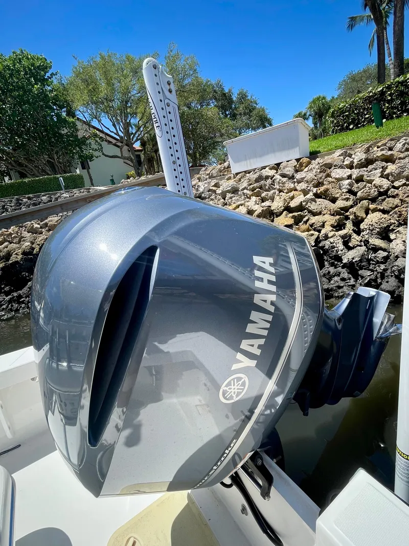 Slide: The Image of Yamaha outboard motor on a 2019 Rambo 27 boat, docked near rocky shore. - 13