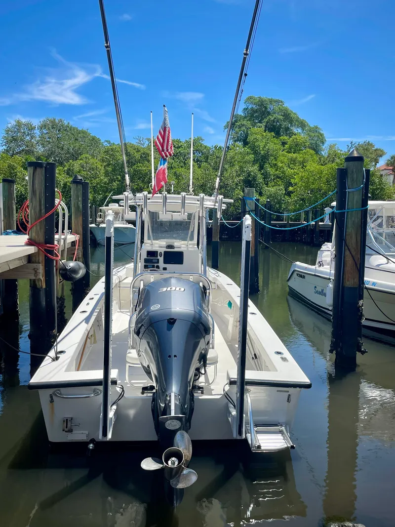 Slide: The Image of 2019 Rambo 27 boat docked with outboard motor and American flag. - 15