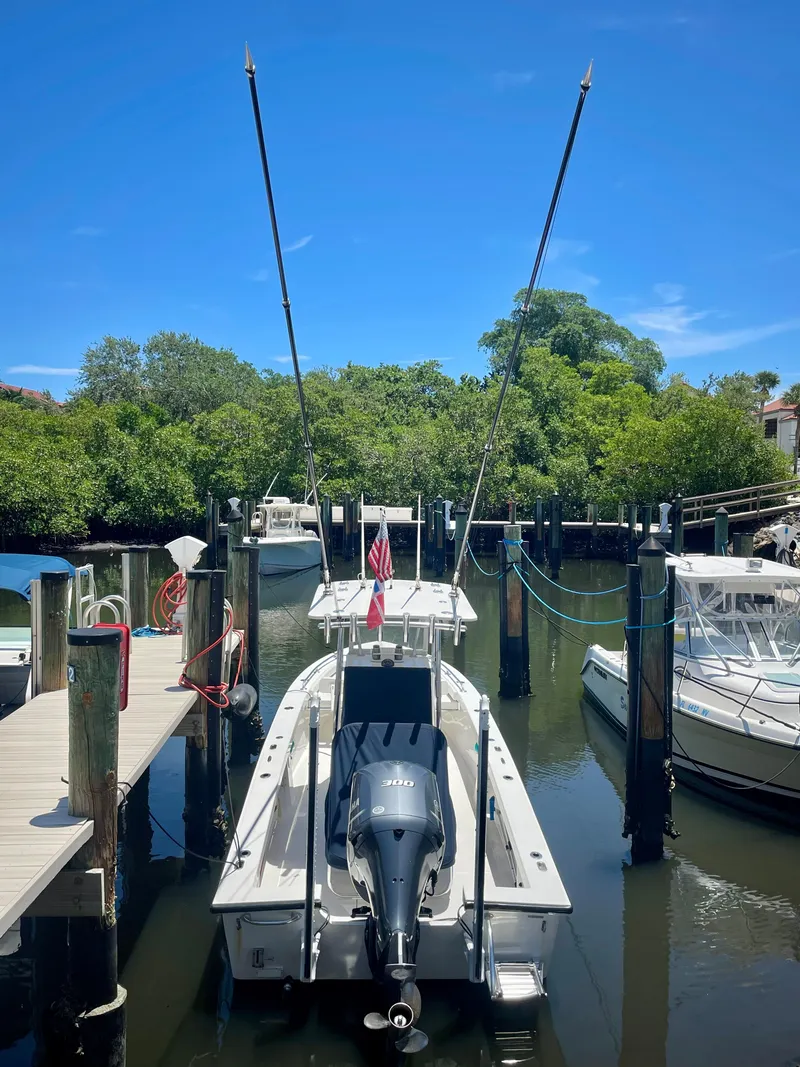 Slide: The Image of 2019 Rambo 27 boat docked at a marina with lush greenery in the background. - 16