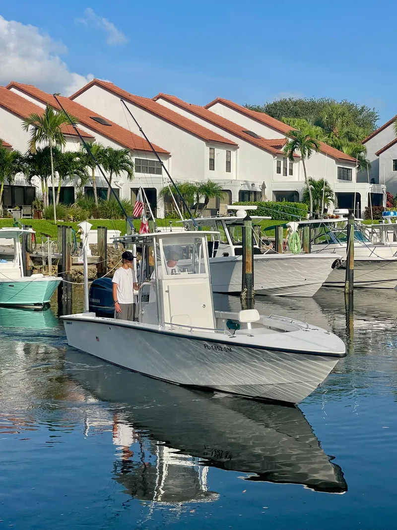 Slide: The Image of 2019 Rambo 27 boat docked near waterfront homes with red roofs. - 18