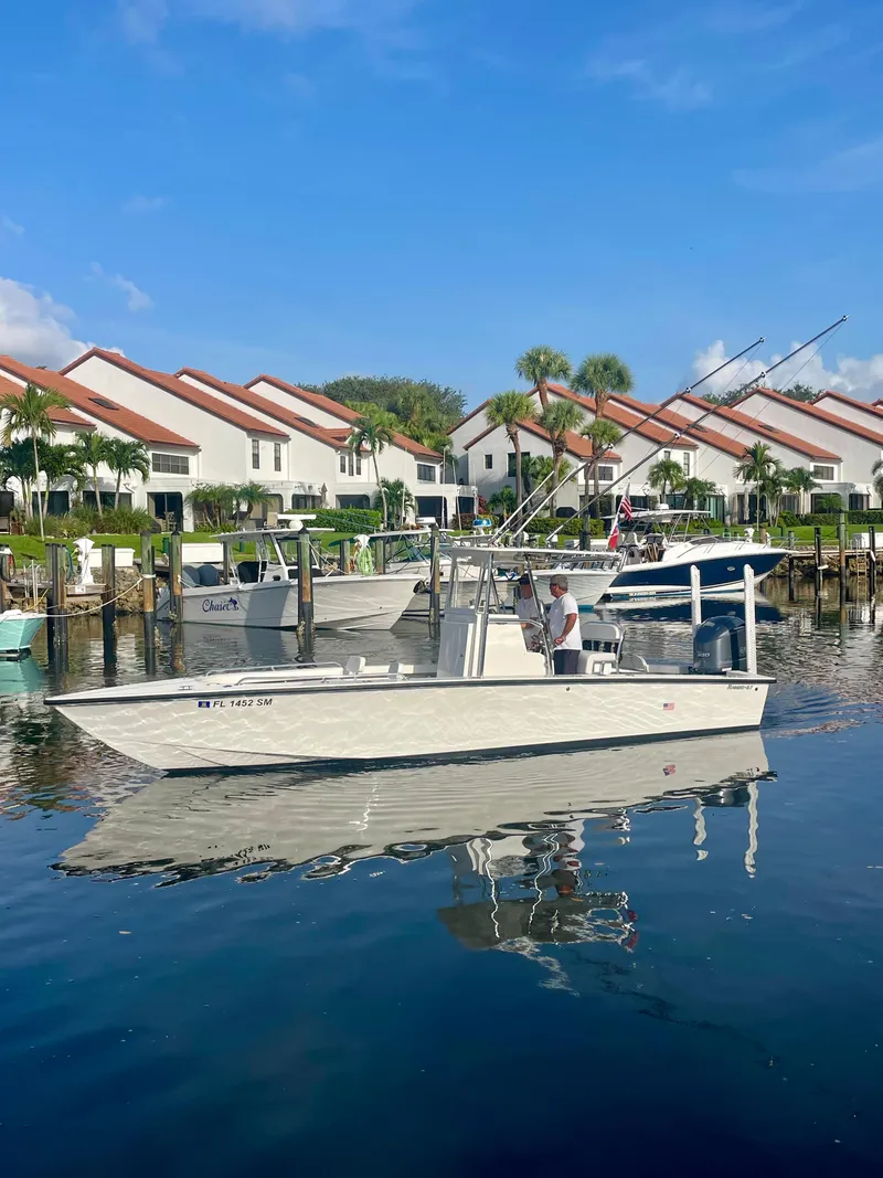 Slide: The Image of Boat docked in marina with townhouses in background, Rambo 27 model, 2019. - 21