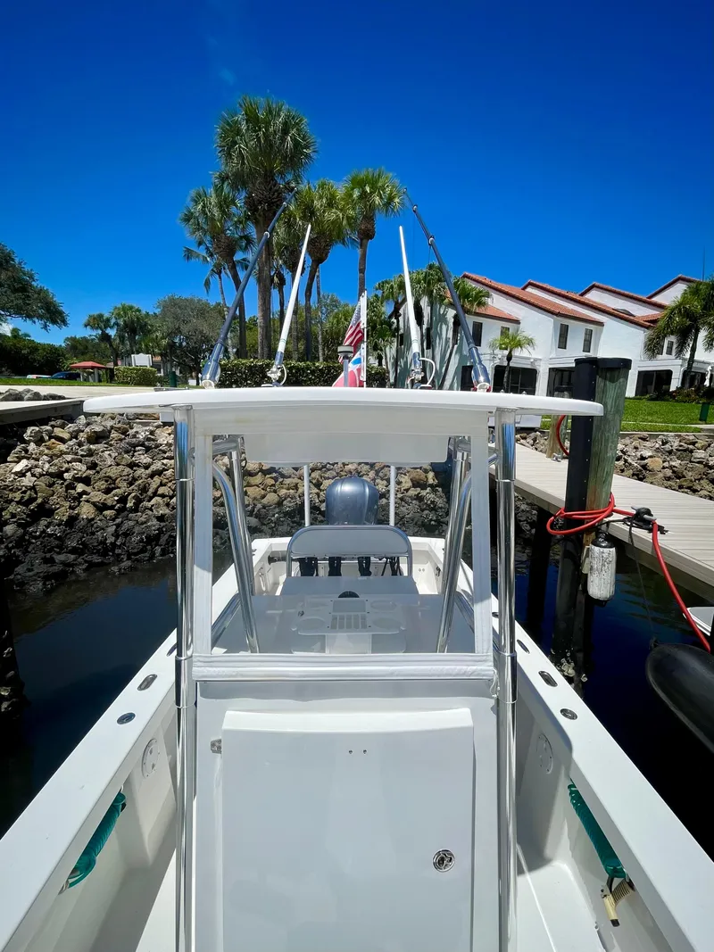 Slide: The Image of 2019 Rambo 27 boat docked at a marina with palm trees in the background. - 7