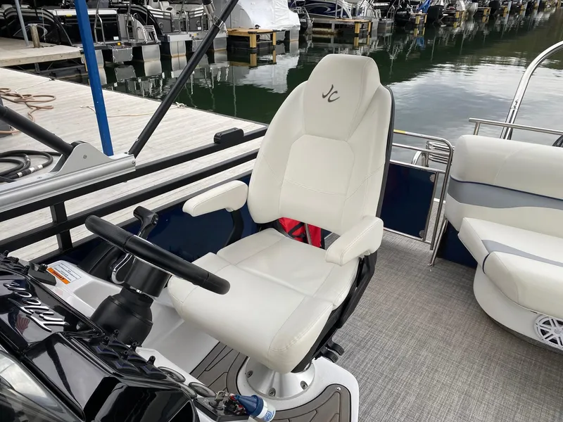 Slide: The Image of Captain's seat on a 2023 JC NEPTOON SPORT 21TT boat at a marina. - 11