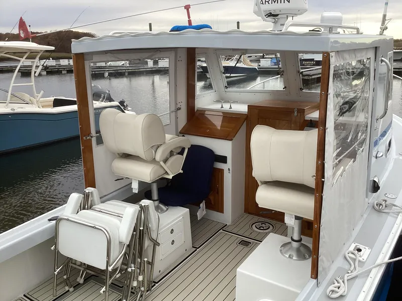 Slide: The Image of 1993 Ellis Downeast Hardtop boat interior with white seats and wooden accents. - 11