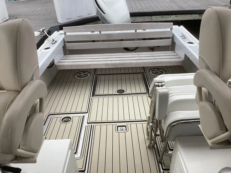 Slide: The Image of 1993 Ellis Downeast Hardtop boat interior with beige seating and wooden flooring. - 13