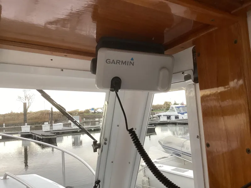 Slide: The Image of Garmin device installed on a 1993 Ellis Downeast Hardtop boat at a marina. - 19