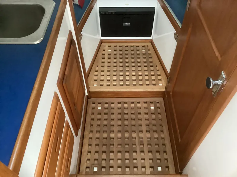 Slide: The Image of 1993 Ellis Downeast Hardtop boat interior with wooden flooring and cabinetry. - 21