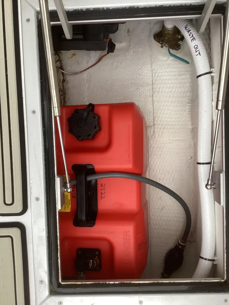 Slide: The Image of 1993 Ellis Downeast Hardtop fuel tank compartment with red fuel tank and hoses. - 23