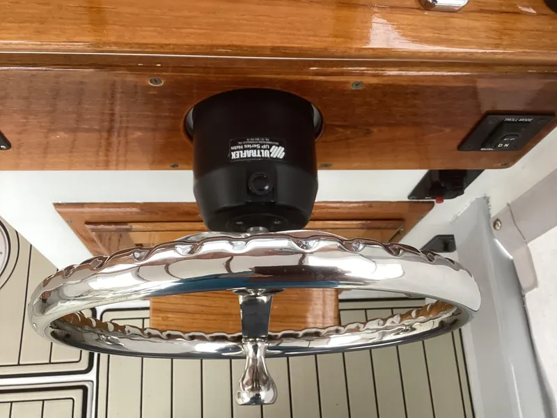 Slide: The Image of 1993 Ellis Downeast Hardtop boat steering wheel and control panel. - 25