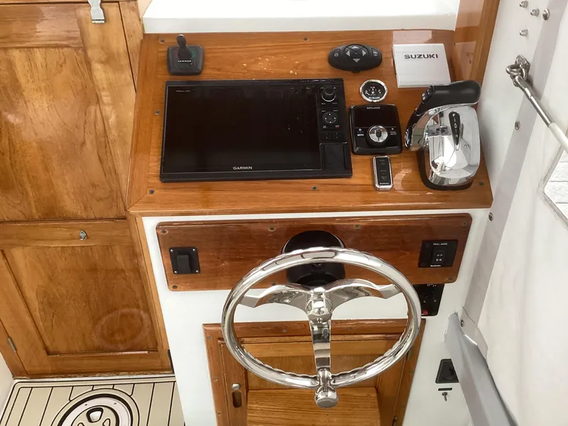 Slide: The Image of 1993 Ellis Downeast Hardtop boat helm with Garmin display and Suzuki controls. - 27