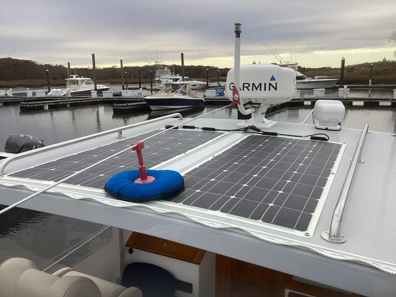 Slide: The Image of 1993 Ellis Downeast Hardtop boat with solar panels and Garmin radar at marina. - 7