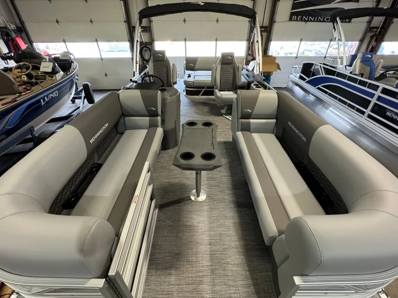 Slide: The Image of 2024 Bennington 22SSB pontoon boat interior with gray seating and central table. - 6