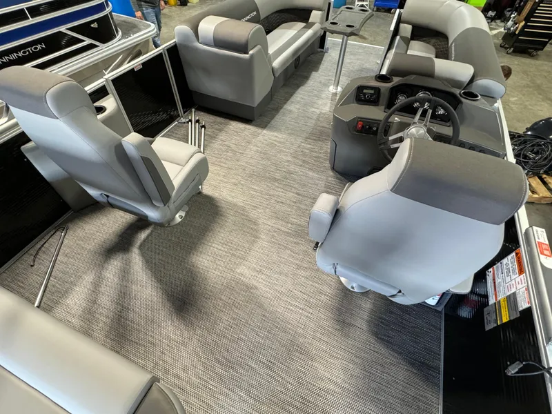 Slide: The Image of 2024 Bennington 22SSB pontoon boat interior with gray seating and steering console. - 7