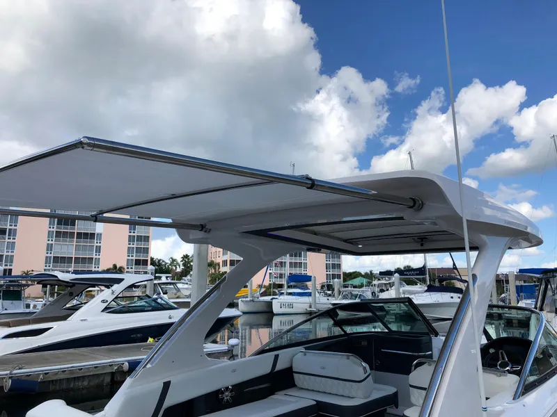 Slide: The Image of 2019 Regal 29 OBX boat with extended canopy at marina. - 2