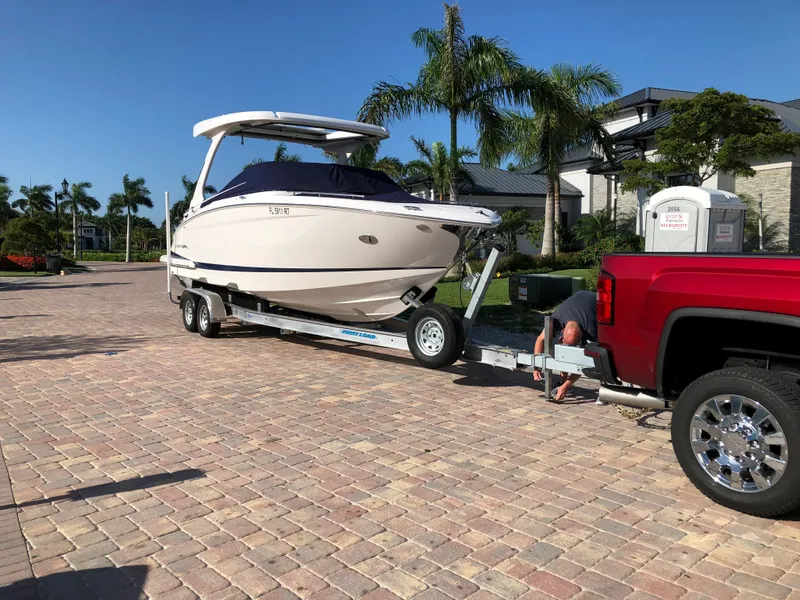 Slide: The Image of 2019 Regal 29 OBX boat on trailer, hitched to red truck in sunny driveway. - 6