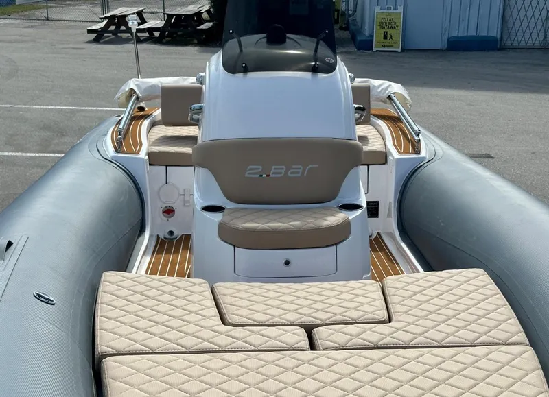 Slide: The Image of 2023 2 Bar 6.20 inflatable boat with beige seating and wooden deck. - 13