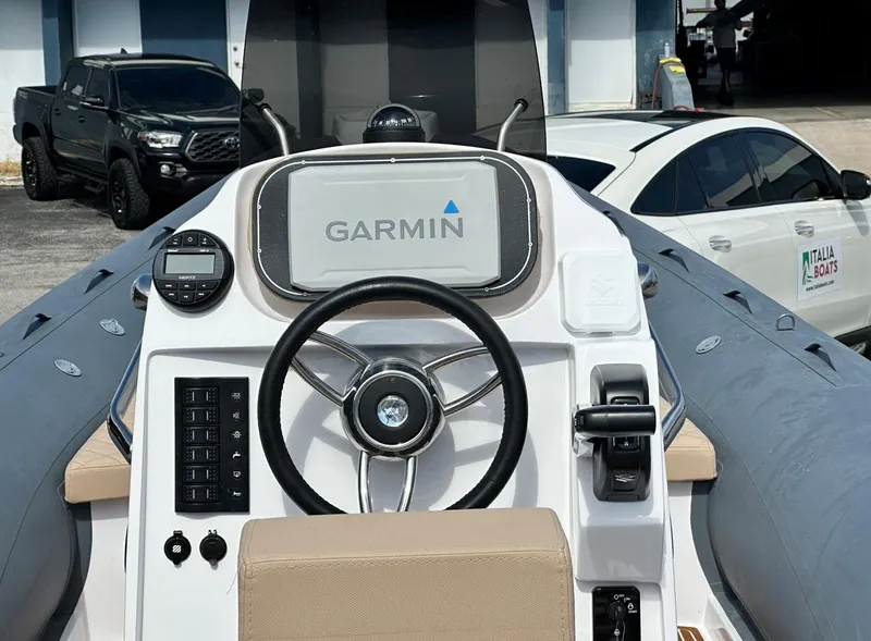 Slide: The Image of 2023 2 Bar 6.20 boat dashboard with Garmin navigation system and steering wheel. - 6