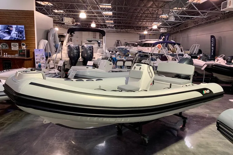 Slide: The Image of 2023 AB Inflatables 15ALX boat displayed in a showroom with other boats. - 2