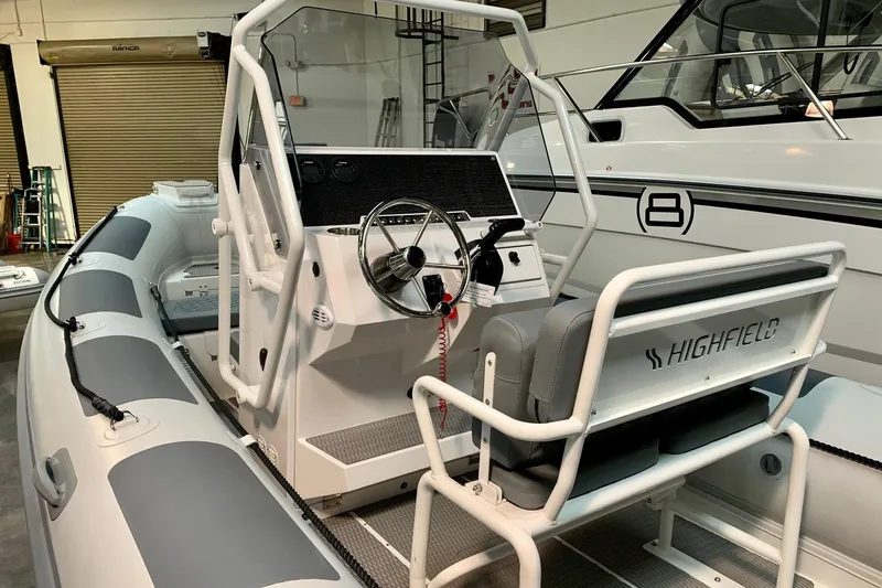 Slide: The Image of 2024 Highfield PA600 inflatable boat interior with steering console and seating. - 2