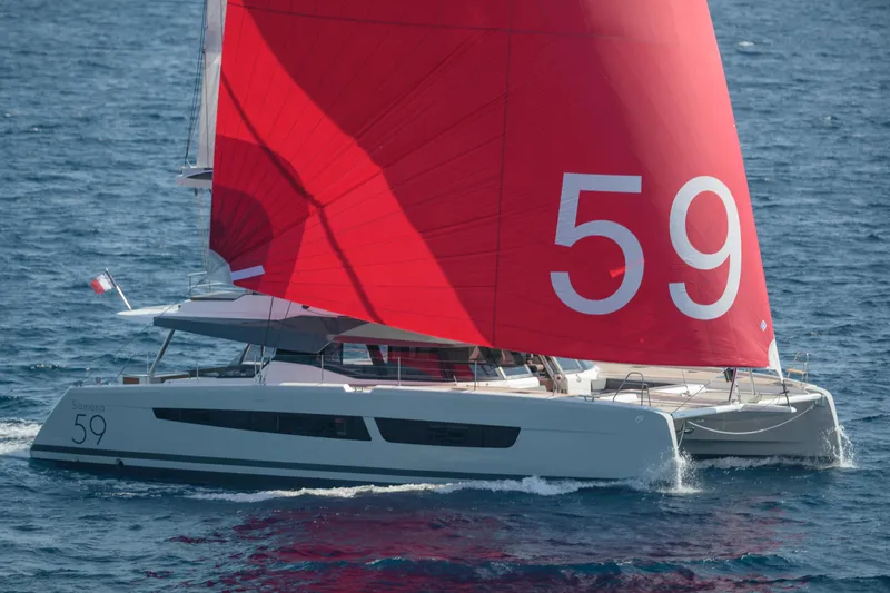Slide: The Image of 2024 Fountaine Pajot Samana 59 catamaran with red sails sailing on the ocean. - 15