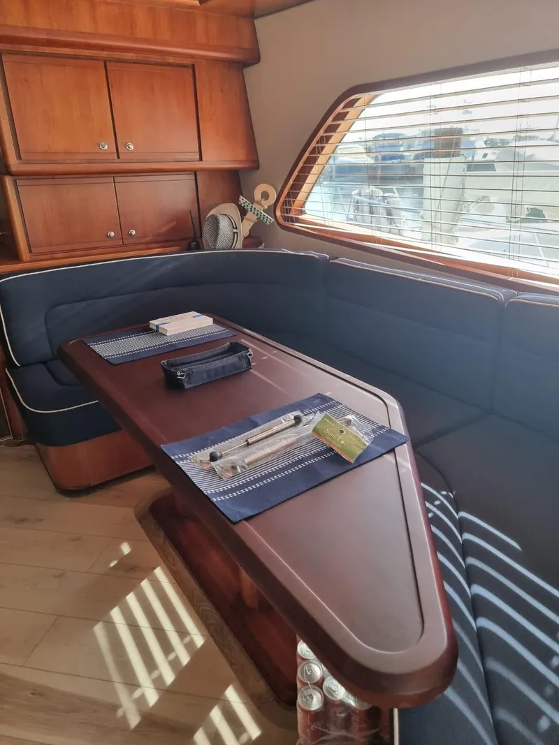 Slide: The Image of Interior of 2008 Bertram 670 Convertible yacht with dining area and wooden cabinetry. - 21