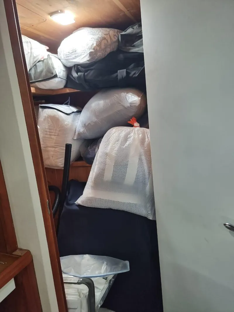 Slide: The Image of Storage area inside a 2008 Bertram 670 Convertible boat filled with bags and equipment. - 26