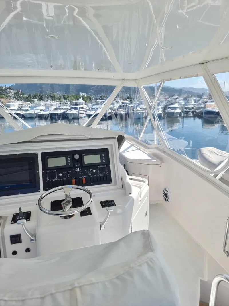 Slide: The Image of Interior helm of a 2008 Bertram 670 Convertible yacht with marina view. - 6