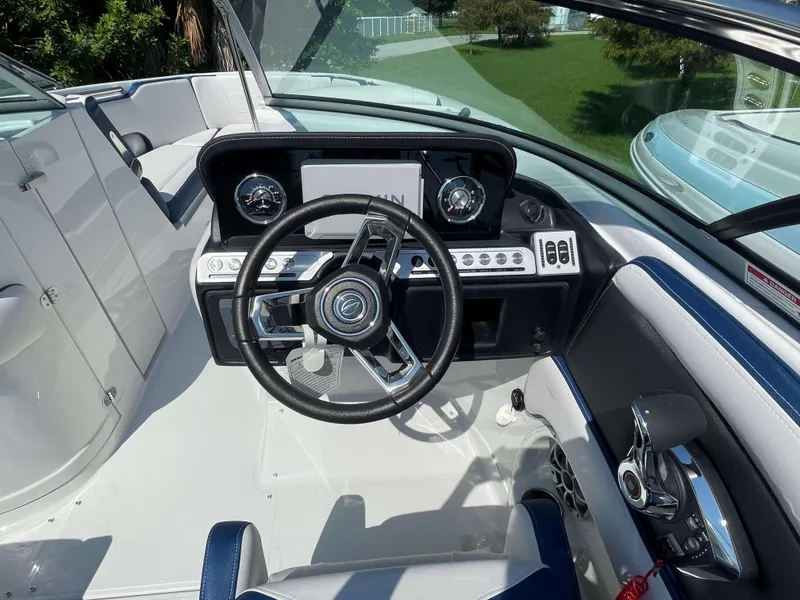 Slide: The Image of 2024 Crownline 250 XSS boat cockpit with modern steering wheel and dashboard controls. - 7