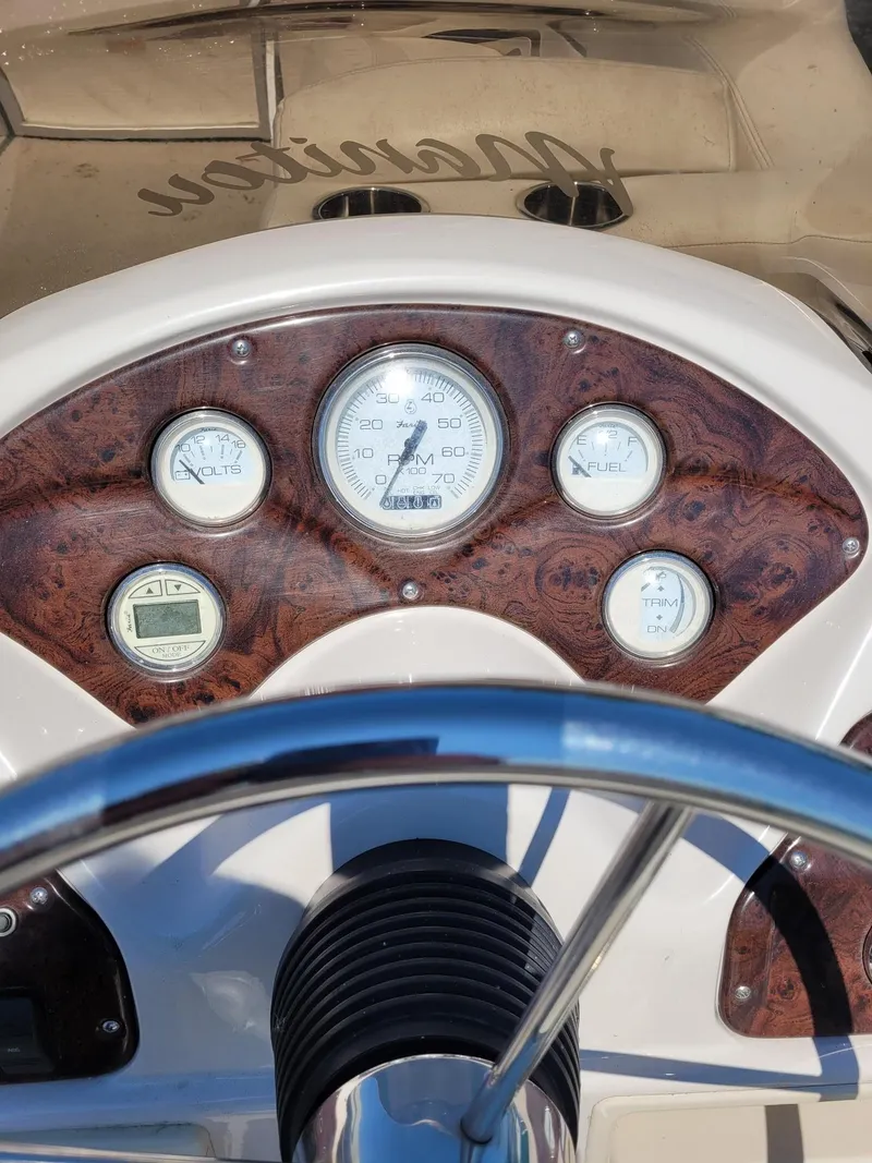 Slide: The Image of Dashboard of a 2008 Manitou 20 Oasis boat with gauges and steering wheel. - 10