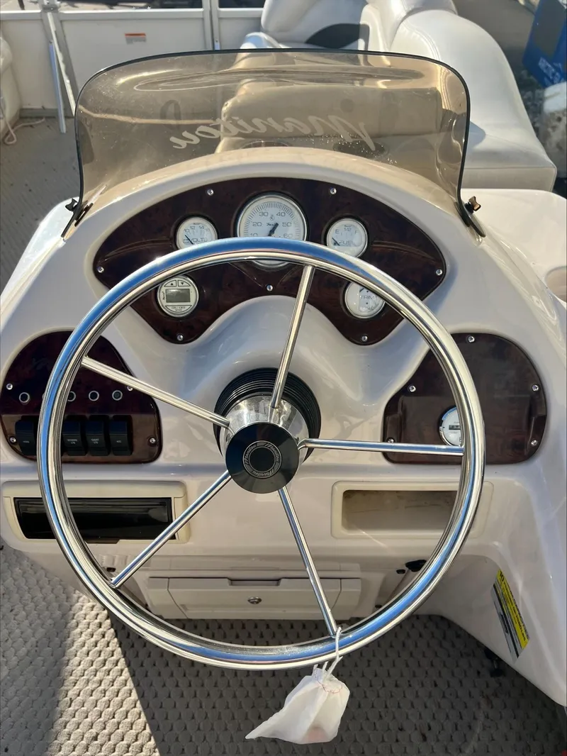 Slide: The Image of 2008 Manitou 20 Oasis boat dashboard with steering wheel and gauges. - 11